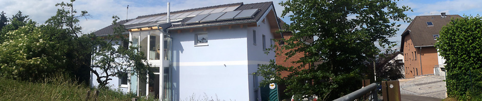 Anfang Juni 2012: das Gerüst um unser Bio-Solar-Haus war abgebaut, die Maler hatten den weißen Streifen aufgemalt und auch der Schornstein für den Kaminofen war montiert worden.