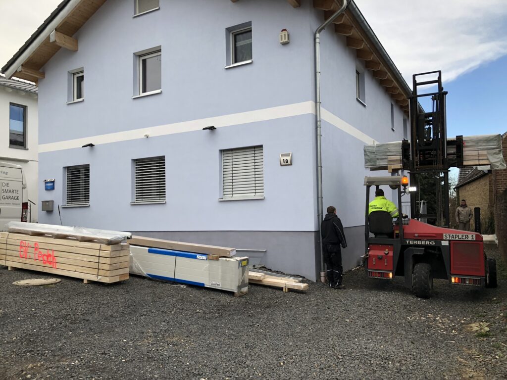 Mit einem Stapler wurden die Teile für den Aufbau der Garage vom Lkw zu unserem Haus transportiert und auf unserem Parkplatz verteilt.